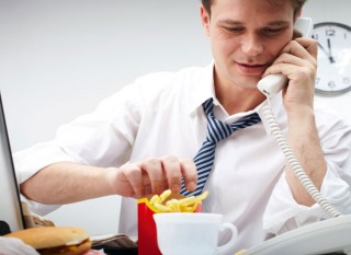 comer en el escritorio y hablando por telefono