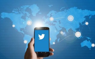 Twitter con telefono y el mundo detras