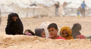 (FILES) This file photo taken on May 4, 2016 shows Syrian refugees waiting to cross to the Jordanian side of the Hadalat border crossing, a military zone east of the capital Amman, after arriving from Syria. The humanitarian situation is getting worse for the 70,000 Syrian refugees stuck on the Jordanian border, since the kingdom blocked the passage of aid following a suicide attack on June 21, 2016 near the make-shift camp, considered by Amman as an 'enclave" of the Islamic State (IS) group. / AFP PHOTO / KHALIL MAZRAAWI