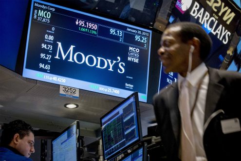 A screen displays Moody's ticker information as traders work on the floor of the New York Stock Exchange January 20, 2015. REUTERS/Brendan McDermid